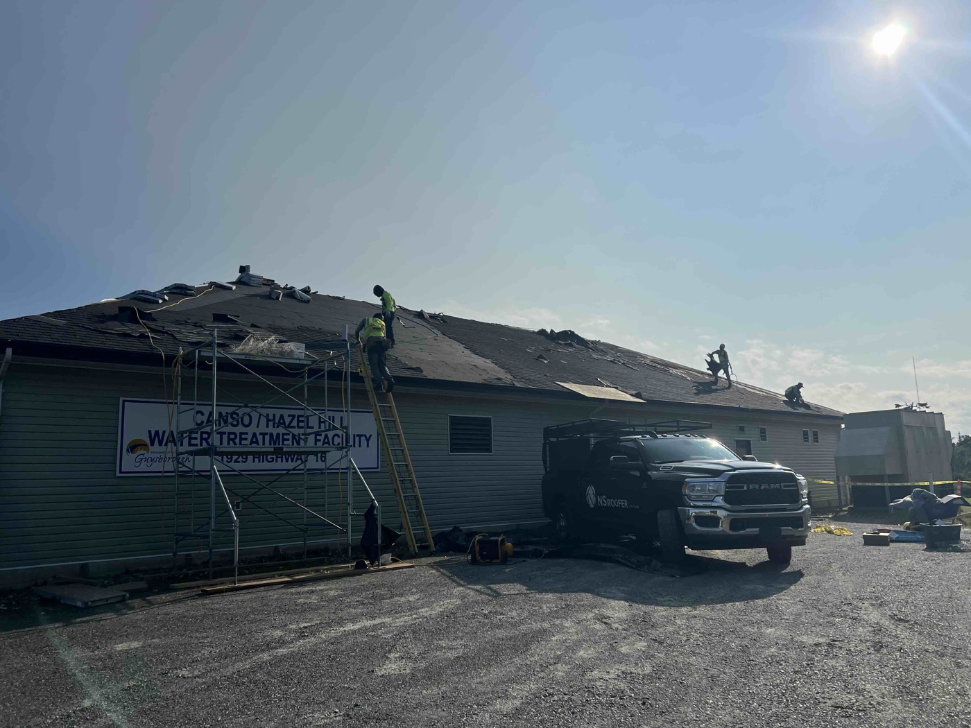 Roofing crew removing the existing shingles from the institutional facility