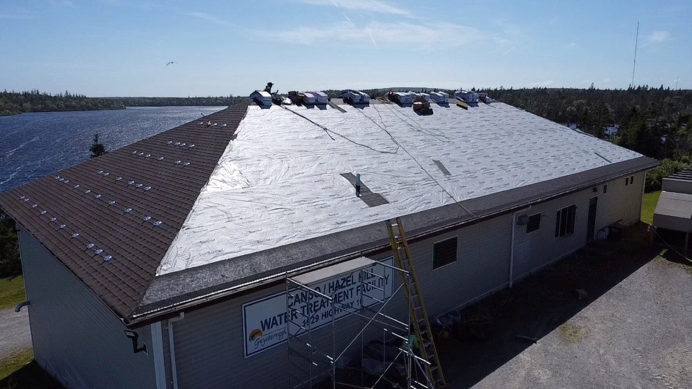Underlayment and shingle installation in progress on the institutional project