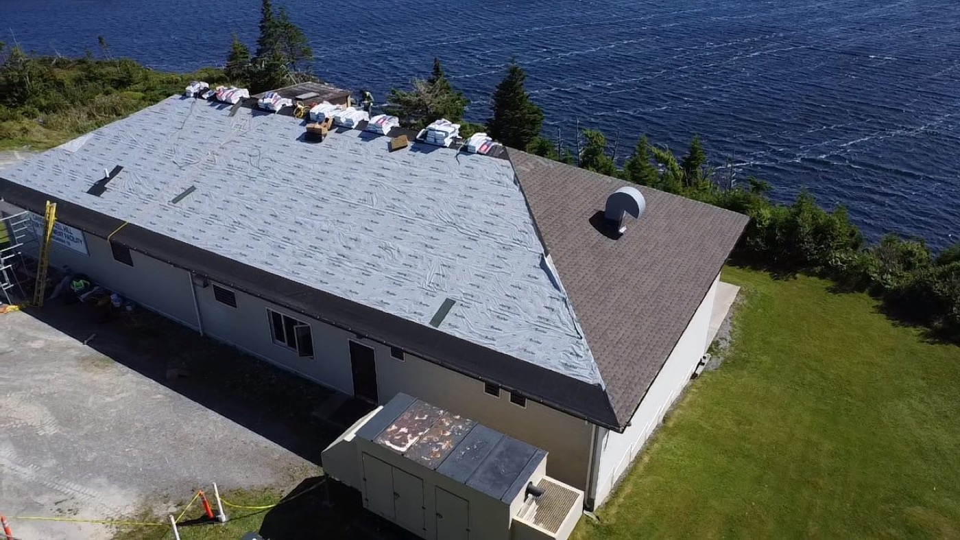 Aerial view of the prepared roof and shingle installation near the water